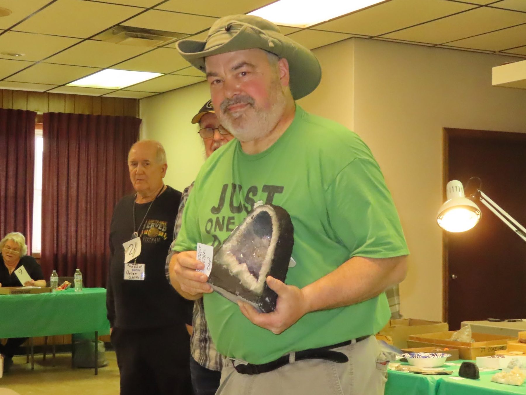 Joe the auctioneer holding up an amethyst geode for bids