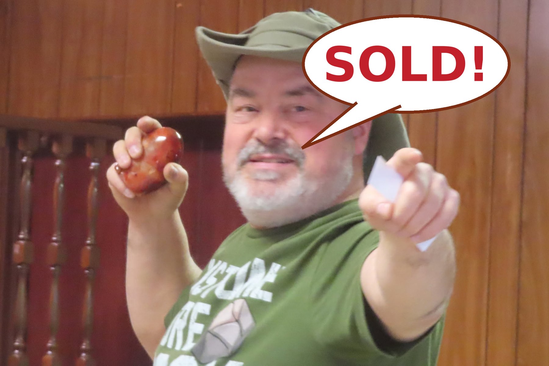 MSNEPA auctioneer holding up a polished carnelian with a comic SOLD! speech bubble