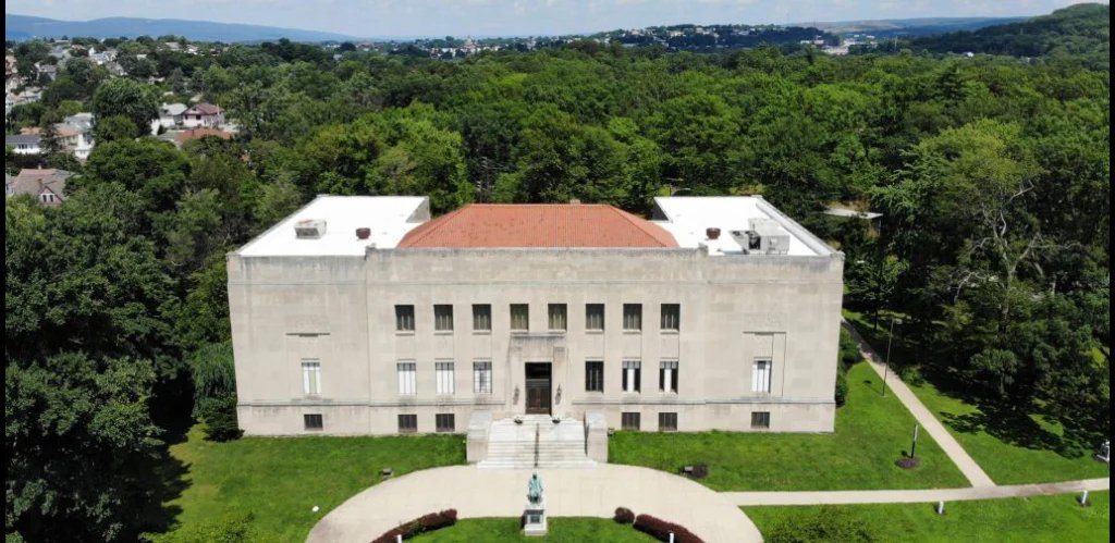 Aerial view of the Everhart Museum, a stone building among the trees of Nay Aug Park in Scranton