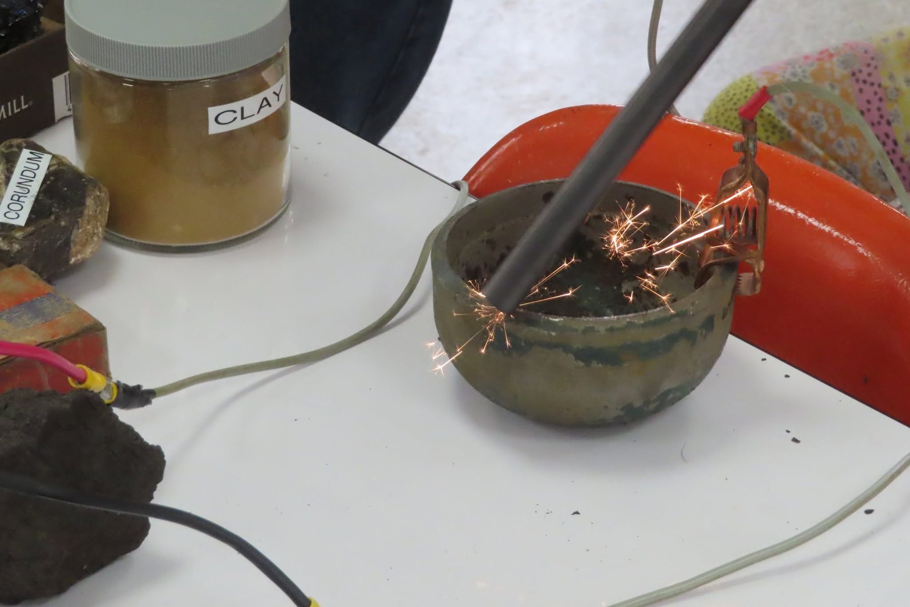 Sparks fly during a hands-on mineral-testing demonstration at a meeting
