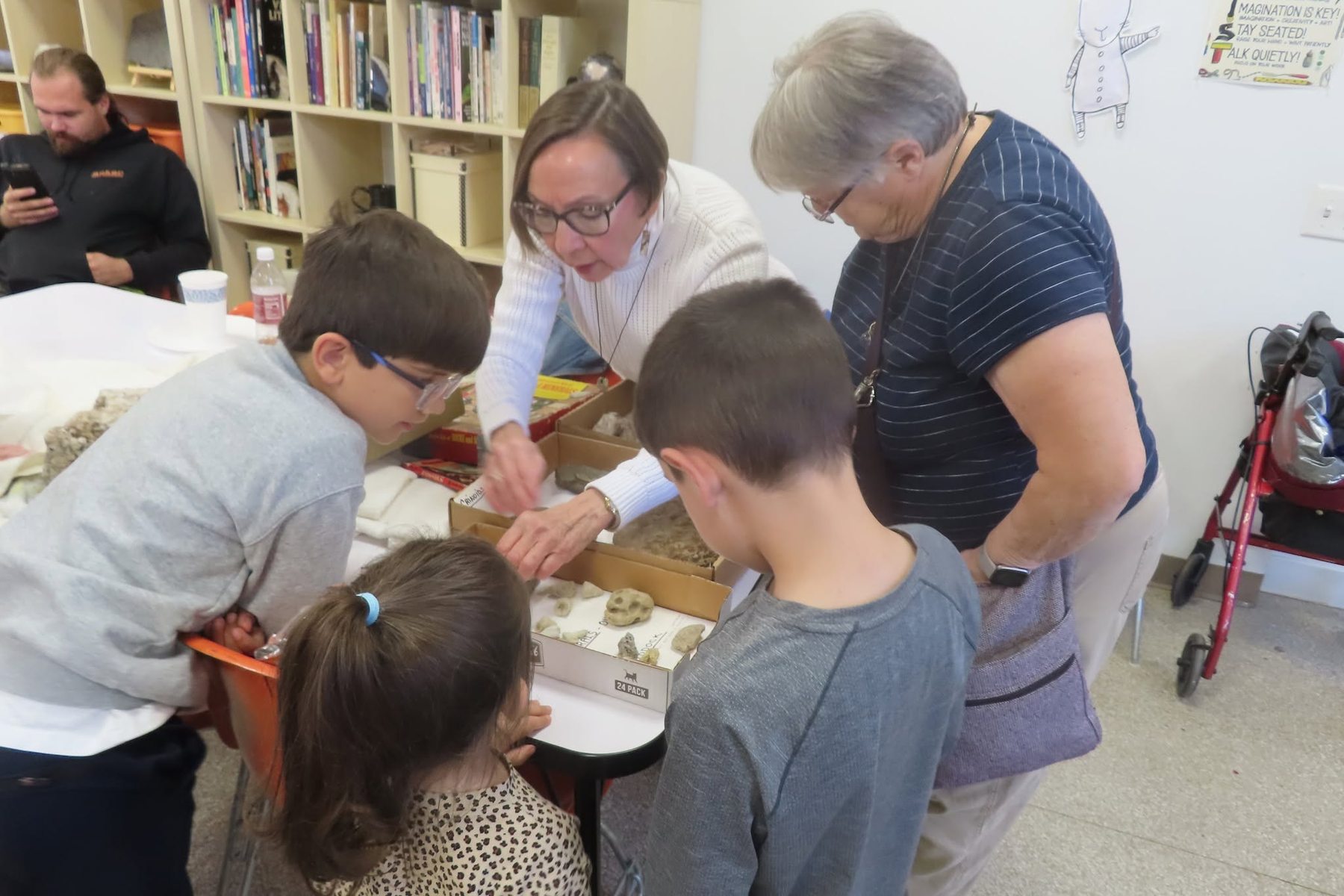 A club member teaching children about fossils at a meeting
