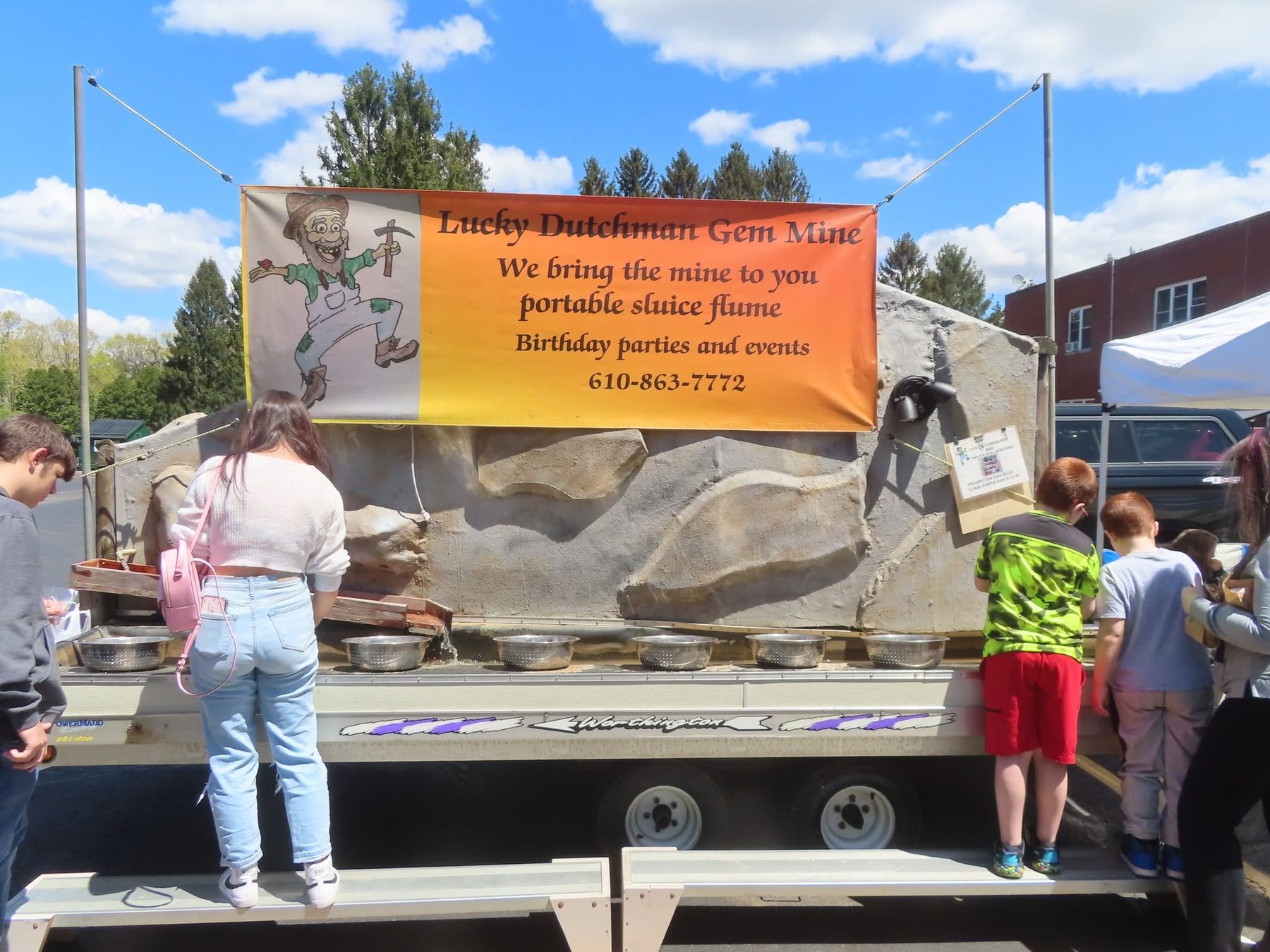 Kids panning for stones at the portable gem-mine sluice outside the show